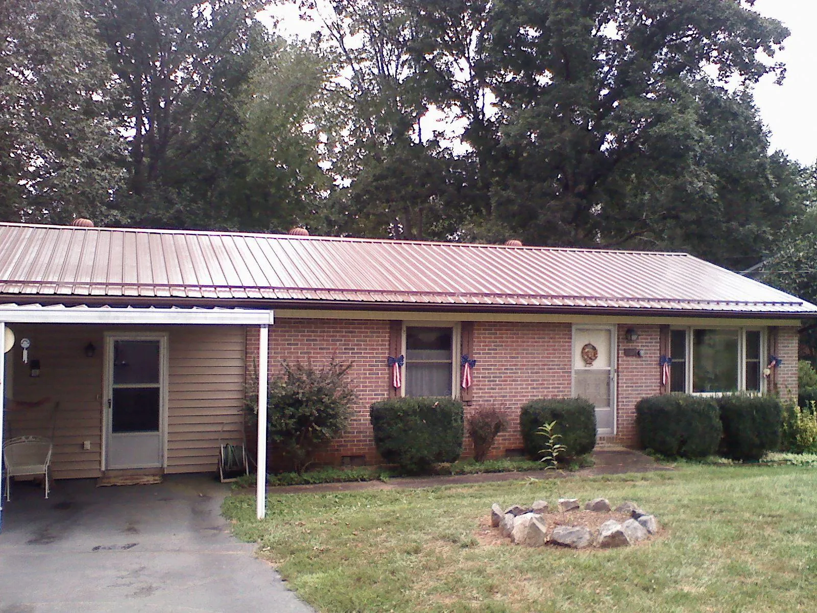 Bronze metal roof and carport on a brick ranch home — Roof Repair work by our crew in Lyndhurst